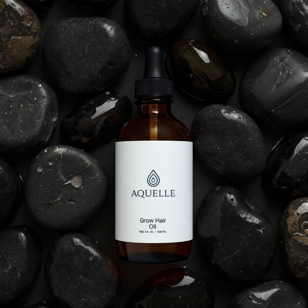 AQUELLE Grow Hair Oil auf nassen schwarzen Steinen – luxuriöses Haaröl für intensives Wachstum und Glanz, präsentiert mit natürlicher Eleganz und Tiefe.